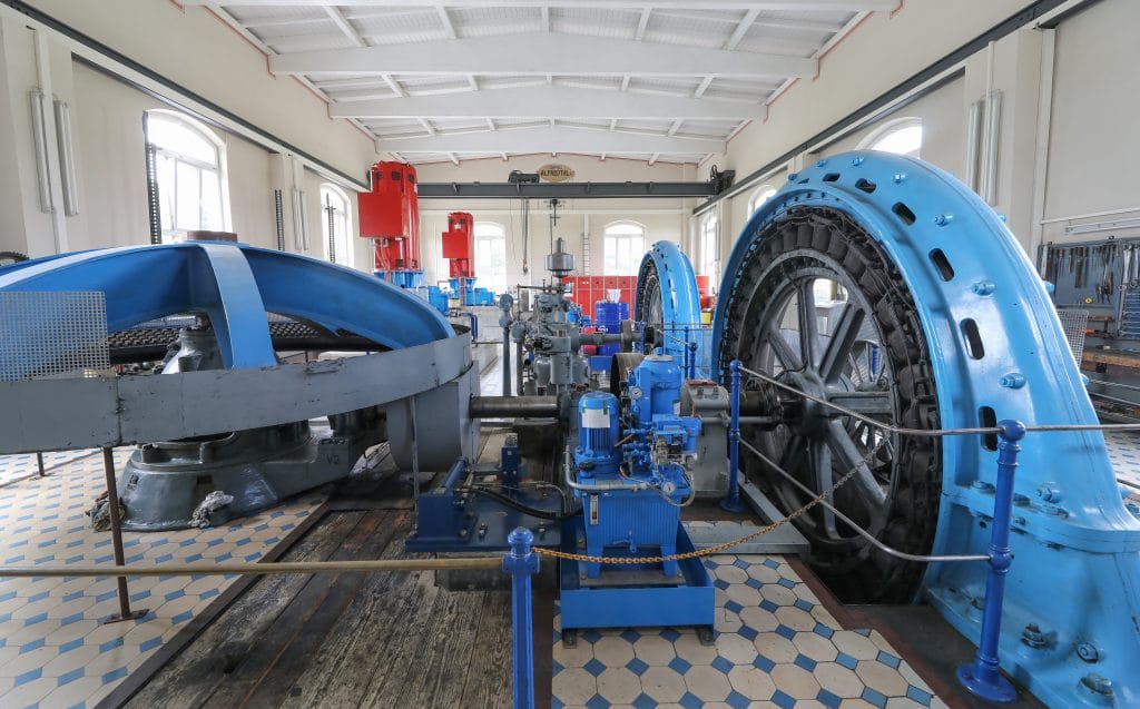 Blau-schwarze Turbinen und Generatoren in einer Halle